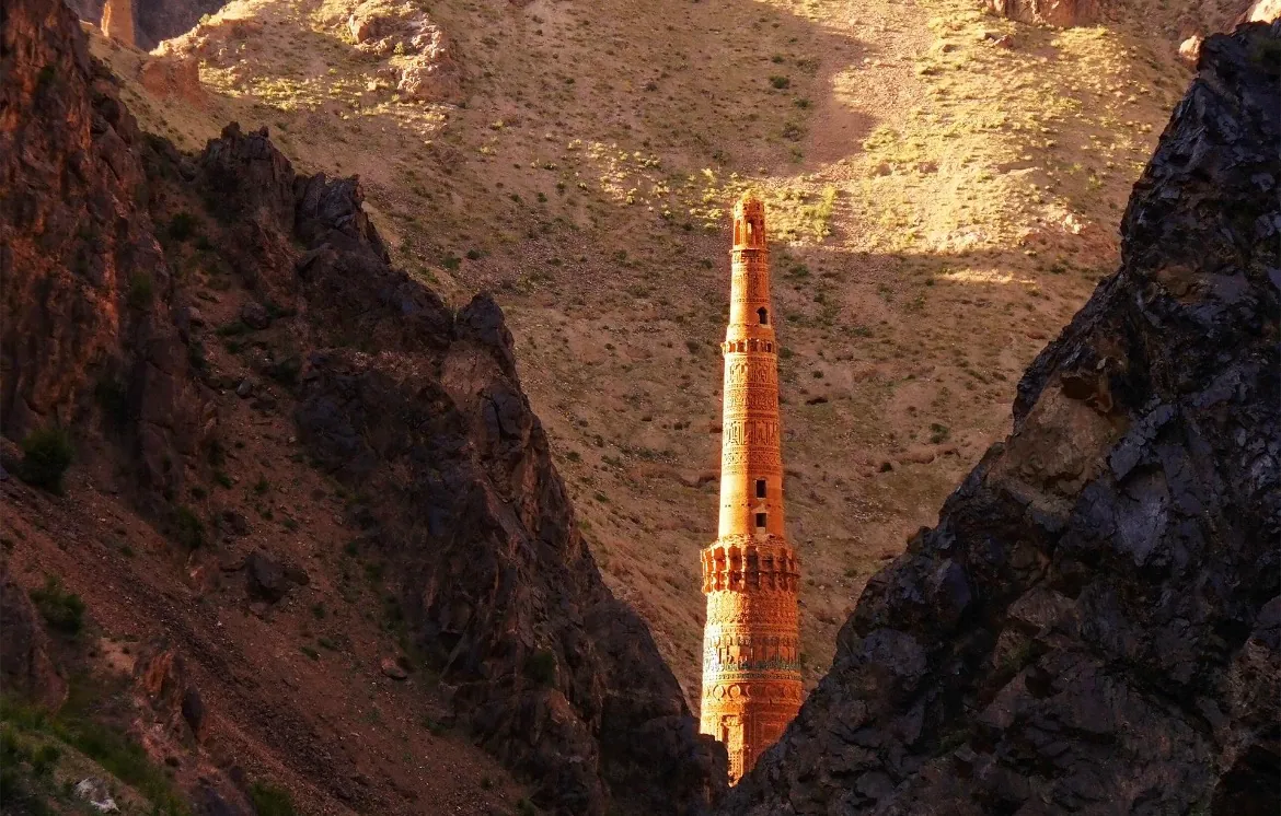 The Minaret of Jam in evening light, framed by the dark rock walls of the Hari River gorge in Ghor