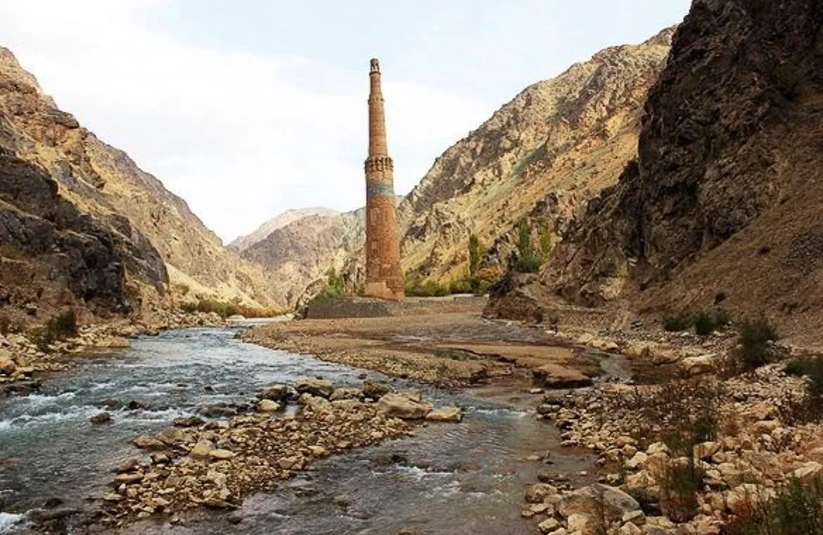 The Minaret of Jam at the end of the Hari River valley, with the river running over stones in front