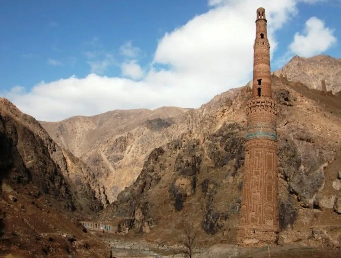 The Minaret of Jam and its band of turquoise tiles, with clouds over the mountains