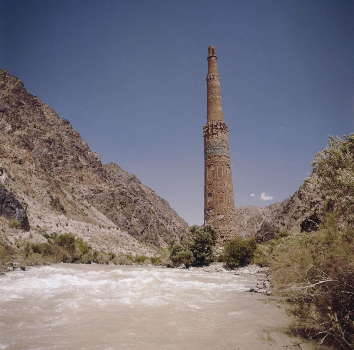The Minaret of Jam above the fast brown water of the Hari River, between steep rocky slopes